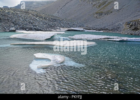 Eisberge aus einem Gletscher gebrochen in einem Gletschersee auf die Berge wie das Klima erwärmt. Stockfoto