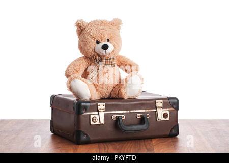 Alte Teddy sitzt auf vintage Koffer. Stockfoto