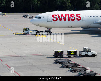 Ein Schleppfahrzeug zieht einen Airbus A340 der Swiss International Air Lines vom Tor am Zürich International Airport. Stockfoto