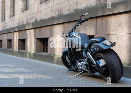 Schwarz Motorrad mit großen Reifen auf dem Bürgersteig. Stockfoto