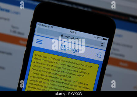 Die wonga Website auf einem Handy und einem Computer Bildschirm angezeigt Stockfoto