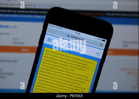 Die wonga Website auf einem Handy und einem Computer Bildschirm angezeigt Stockfoto