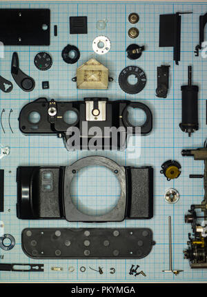 Teile sind vollständig demontiert alten retro Film SLR Kamera auf Millimeterpapier, close-up Stockfoto
