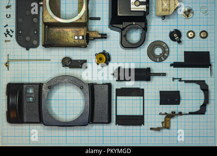 Teile sind vollständig demontiert alten retro Film SLR Kamera auf Millimeterpapier, close-up Stockfoto