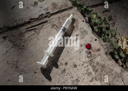 Weggeworfene Spritze auf Beton im Freien - Nahaufnahme Droge Konzept Bild Stockfoto