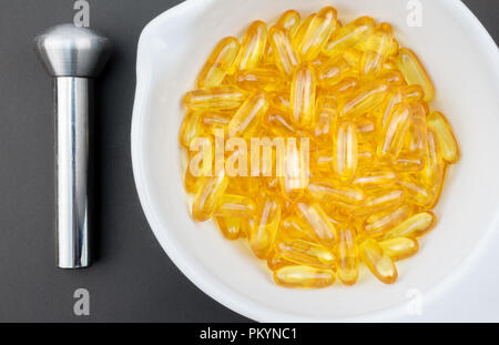 Omega 3 Kapseln Mörser mit Pistill auf grauem Hintergrund - Ansicht von oben Foto Stockfoto