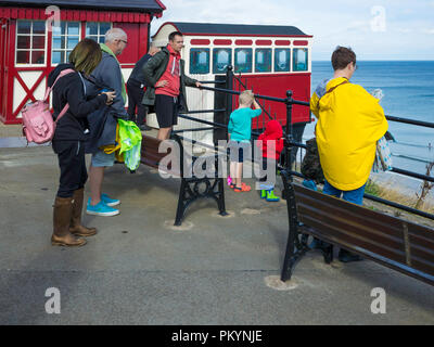 Eine Familie an der Bergstation der Standseilbahn Straßenbahn Saltburn Klippe nach unten am Pier Stockfoto