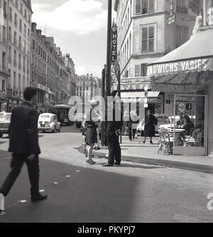 1960, historische, eine junge blonde Frau in einem Gespräch mit einem französischen Polizisten auf der Ecke einer Straße in Paris, Frankreich. Stockfoto