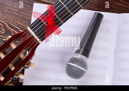 Gitarre, Noten und Mikrofon. Vocal Mikrofon auf Noten. Musikalische Ausrüstung für Konzert. Stockfoto