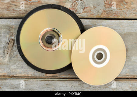 DVD-Discs auf alten hölzernen Hintergrund. Stapel von Cds auf Holzmöbeln im Landhausstil Oberfläche. Veraltete Digital Data Storage. Stockfoto