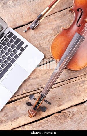 Vintage Violine und Laptop auf Holzplatten. Stockfoto