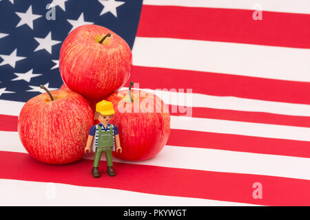 Rote Äpfel + US-amerikanische Flagge / Stars & Stripes. US-Lebensmittelexporte, US-amerikanische apfelindustrie, chinesische Handelszölle auf importierte amerikanische Äpfel. Stockfoto
