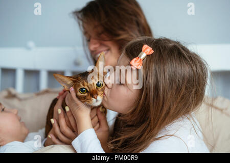 Glückliche Mutter und Tochter lächelnd umarmt im Bett Stockfoto