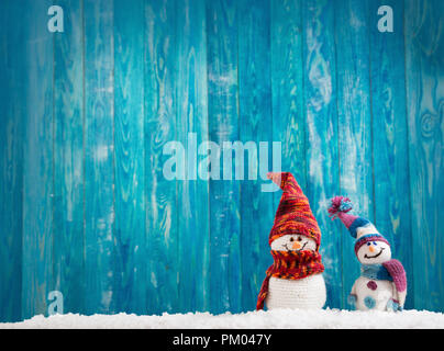 Wenig snowmans auf weichem Schnee auf blauem Hintergrund Stockfoto
