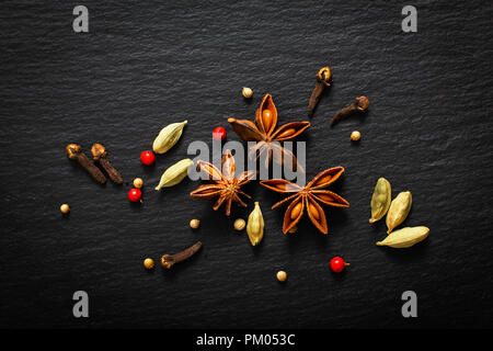 Essen Hintergrund Nahaufnahme organische verschiedene Gewürze auf schwarzem Schiefer board Stockfoto