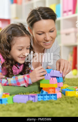 Curly kleines Mädchen und ihre Mutter spielen Stockfoto