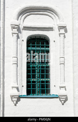 Kirche Fenster mit Gittern von der Straße. Weißes Gebäude. Stockfoto