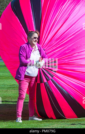 Frau helfen bei der Vorbereitung Modell Heißluftballon am Himmel Longleat Safari, Wiltshire, UK im September Stockfoto