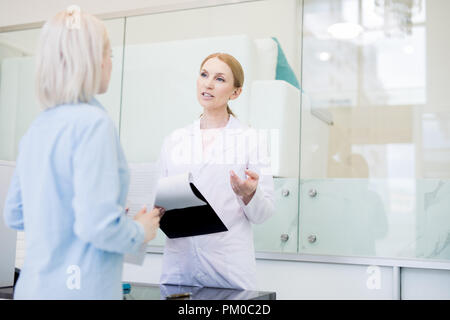 Zuversichtlich Apotheke Manager in Jungtieren Beratung eines Kunden über neue Medizin Stockfoto