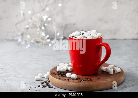 Heiße Schokolade mit Marshmallows in einem roten Tasse auf einem grauen Stein Hintergrund Stockfoto