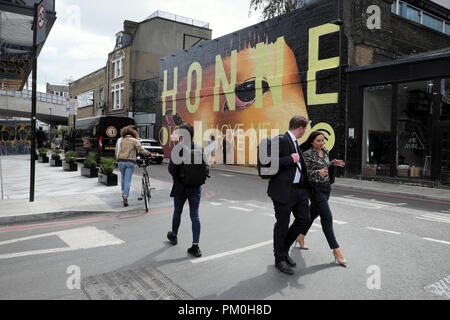 Leute, die in der Straße vor dem Bürger M Hotel Vergangenheit HONNE Wandbild street art Malerei auf Holywell Lane in Shoreditch East London UK KATHY DEWITT Stockfoto