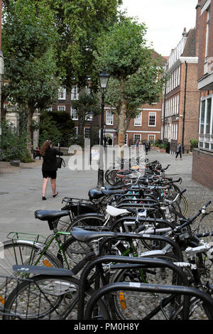 Frau Vergangenheit abgestellte Fahrräder wandern in Fahrradständer in Grays Inn, London WC 1 UK KATHY DEWITT Stockfoto
