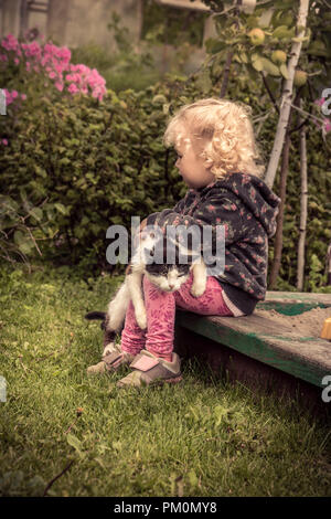 Lustige Kitty auf kid Knie nach dem Spielen mit Kind Konzept pet Care erschöpft Stockfoto