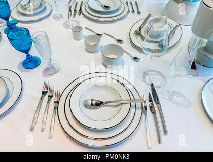 Ein Tisch mit Gläsern und Flaschen, Gläser und Tassen sowie das Geschirr Stockfoto