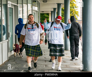 Leith, Edinburgh, Schottland, Großbritannien, 16. September 2018. Edinburgh Kilt Walk, gesponsert von der Royal Bank of Scotland, findet heute statt. Wanderer sammeln Mittel für eine Wohltätigkeitsorganisation ihrer Wahl. Die Kilt-Wanderer erreichen die Küste bei etwa 14 km im Regen. Zwei Männer in Kilts gehen vorbei, um Geld für wohltätige Zwecke zu sammeln Teenage Cancer Trust. Ein Mann hebt seine Hände mit einer Geste nach oben Stockfoto