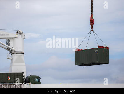 Emden, Deutschland. 16. September 2018. Ein Container der Bundeswehr (Bundeswehr) auf einem Ro-ro-Schiff mit dem Kran in Emden Hafen geladen wird. Die NATO-Übung "Trident Zeitpunkt 2018 (TRJE 18)" in Norwegen findet vom 25. Oktober bis 7. November statt. Die Bundeswehr ist fast 10.000 Soldaten und mehr als 4.000 Fahrzeuge nach Norwegen zu übertragen. Ein Schiff wird mit rund 300 Fahrzeugen und Panzern sowie 95 Container im Hafen von Emden geladen. Foto: mohssen Assanimoghaddam/dpa Stockfoto