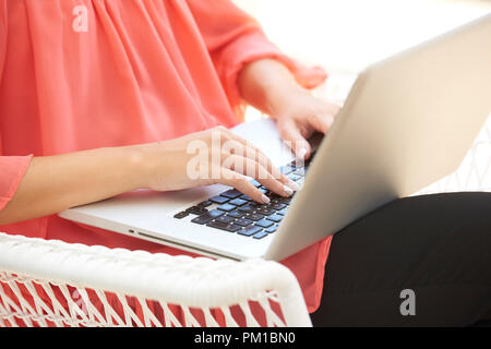 7/8 Schuß von der Hand einer Frau, die während der Eingabe auf der Tastatur des Notebooks. Stockfoto