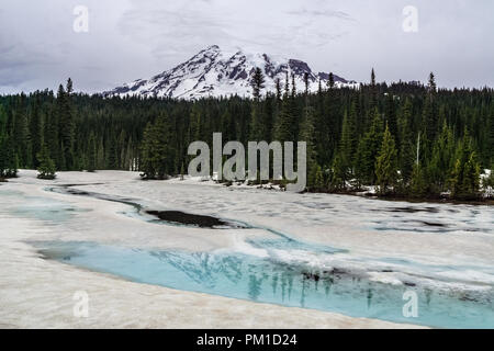 Mount Rainier bedeckt mit Schnee auf dem blauen Gletscherwasser der gefrorenen Reflexion Seen widerspiegelt, Mt Rainier National Park, Washington State, USA. Stockfoto