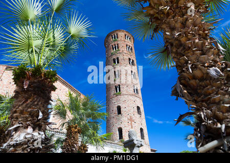Turm der Basilika Sant'Apollinare in Classe Ravenna zwischen Palmen vor einem hellblauen Himmel Stockfoto