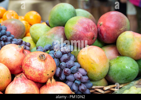 Frische Mangos, Trauben, Orangen & Pomegranetes auf Verkauf in Borough Markt, Southwark, London, UK Stockfoto