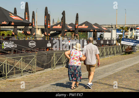 Reifes Paar zu Fuß über einen Fußweg entlang des Flusses Vltava im Zentrum von Prag. Stockfoto