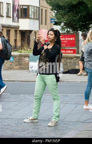 Frau unter Foto mit Telefon Stockfoto