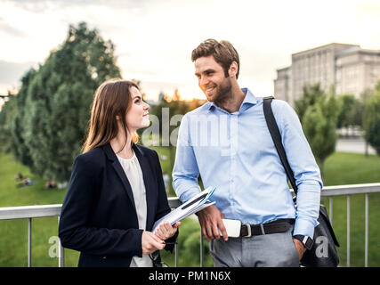 Ein junger Geschäftsmann und Geschäftsfrau steht auf einer Brücke. Stockfoto