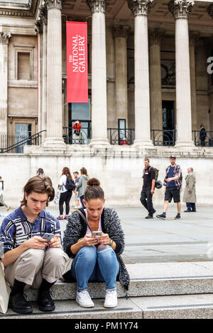 London England, Großbritannien, Trafalgar Square, Nationalgalerie, Fassade, plaza, auf der Treppe sitzend, junge Jungen, männliche Kinder, Kinder, Jugendliche, Mädchen, weibliche Te Stockfoto