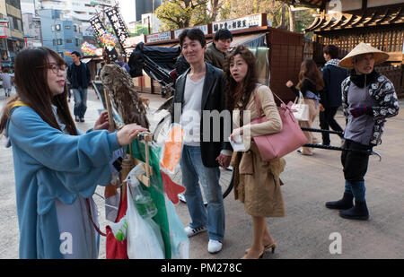 Junge japanische Frau, die Werbung und die Förderung der lokalen Bar, wo Kunden pet und wilden Tieren berühren kann. Bezirk in Asakusa, Tokyo, Japan, Asien Stockfoto