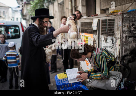 17. September 2018, ---, Jerusalem: Eine ultra-orthodoxe jüdische schwingt ein Huhn über den Kopf einer jungen Frau, die als Teil der jüdischen Ritual "Kaparot', die vor dem Yom Kippur, dem Versöhnungstag, in Jerusalem, 17. September 2018 durchgeführt. Die 'Kaparot' Ritual ist auf Transfers Sünden aus dem vergangenen Jahr in Hühner geglaubt, und vor Yom Kippur, der heiligste Tag im Jüdischen Kalender durchgeführt. Foto: Ilia Yefimovich/dpa Quelle: dpa Picture alliance/Alamy leben Nachrichten Stockfoto