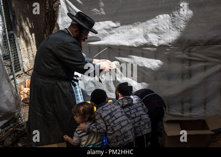 17. September 2018, ---, Jerusalem: Eine ultra-orthodoxe jüdische schwingt ein Huhn über die Köpfe seiner Kinder als Teil des jüdischen Ritual "Kaparot', die vor dem Yom Kippur, dem Versöhnungstag, in Jerusalem, 17. September 2018 durchgeführt. Die 'Kaparot' Ritual ist auf Transfers Sünden aus dem vergangenen Jahr in Hühner geglaubt, und vor Yom Kippur, der heiligste Tag im Jüdischen Kalender durchgeführt. Foto: Ilia Yefimovich/dpa Quelle: dpa Picture alliance/Alamy leben Nachrichten Stockfoto