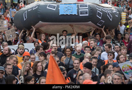 17. September 2018, Hessen, Frankfurt Main: Mehrere tausend Menschen, die sich in einem gemeinsamen Demonstrationszug durch die Innenstadt. Sie tragen ein riesiges Schlauchboot, die auch von Flüchtlingen auf dem Mittelmeer verwendet wird. Auf Banner und Plakate, die Sie für eine Änderung in der Migrationspolitik in Deutschland anzurufen und gegen Bundesminister Horst Seehofer (CSU). Foto: Boris Roessler/dpa Stockfoto
