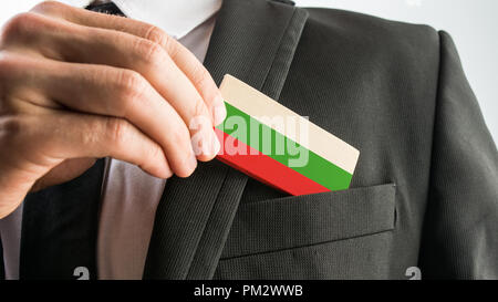 Mann, einen Holz- Karte wie der Bulgarischen Fahne aus seinem Anzug Tasche gemalt, in der Nähe von seiner Hand. Stockfoto