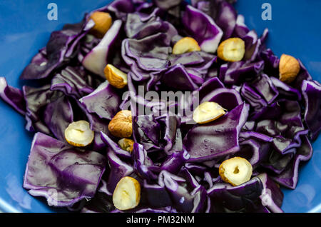 Nahaufnahme von roten gehackten Kohl mit Haselnüsse in eine blaue Schale serviert. Stockfoto