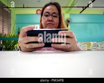 Foto einer Frau mit Brille mit einem Smartphone Stockfoto