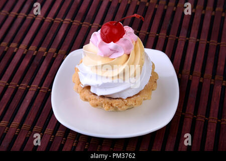 Leckere hausgemachte Kuchen, Muffin mit Sahne und Kirschen. Nahaufnahme süßen Nachtisch. Stockfoto