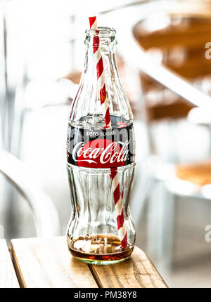 Ein leeres Glas Flasche Coca Cola mit Strohhalm hinein. Stockfoto