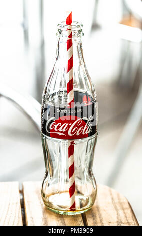 Ein leeres Glas Flasche Coca Cola mit Strohhalm hinein. Stockfoto