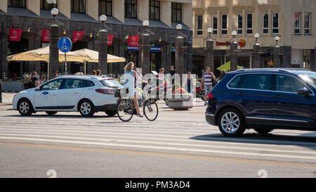 RIGA, Lettland - 31. JULI 2018: Radfahrer und Fußgänger die Straße überqueren, durch eine Fußgängerampel. Stockfoto