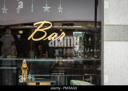 RIGA, Lettland - 31. JULI 2018: Durch die bar Fenster ist Kellner zu sehen. Fenster Reflexion kann in einem Souvenir Kioske gesehen werden. Stockfoto